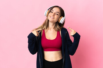 Young Romanian sport woman isolated on pink background giving a thumbs up gesture