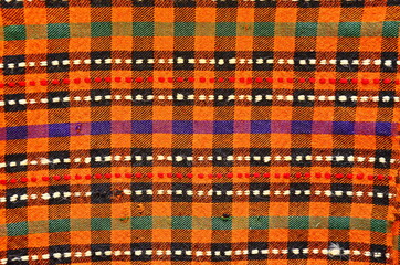 Background of an old worn carpet sewn with thick threads.