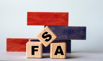FSA - acronym on wooden cubes on a background of colored block on a light background