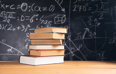 stack of books on blackboard background