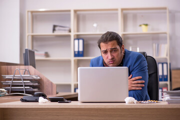 Young sick businessman employee suffering at workplace