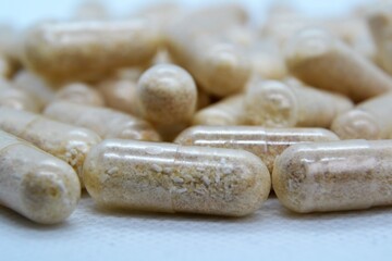 Beige oval pills, tablets. Medicines on the white background. Pile of pills, capsules. Addiction to drugs and supplements. Medical and healthcare concept. 