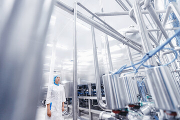 Industrial portrait operator female in uniform background food factory production line