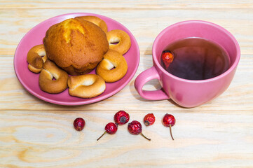 Homemade round bagels with muffins in a purple plate and rosehip tea. Idea for a delicious breakfast or dinner