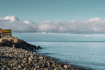 Fog Clouds Lifting in the Morning Sun Starts to revel the Olympic Mountains From Whidbey Island Wa.