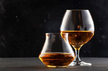 Cognac and scotch wisky in glasses, dark background, selective focus