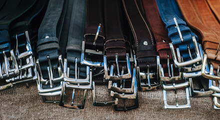 Fototapeta na wymiar Lots leather belts background. Classic men's leather belts