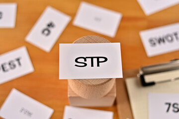 There is a piece of paper with the word STP written on it. It was an abbreviation for Segmentation, Targeting, Positioning.