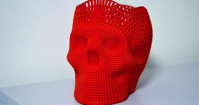 Skull printed with plastic of red color on a 3d printer.
