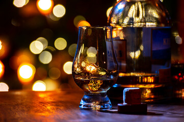 Glasses of scotch whisky served in bar in Edinburgh, Scotland, UK and pasry lights on background