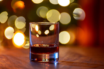 Glasses of scotch whisky served in bar in Edinburgh, Scotland, UK and pasry lights on background
