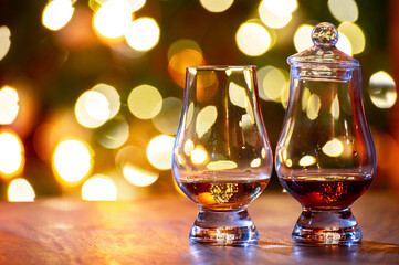 Glasses of scotch whisky served in bar in Edinburgh, Scotland, UK and pasry lights on background