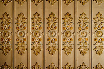 The molding with leaf patterns on the ceiling is white and gold.