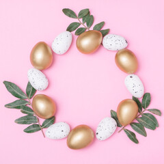 Golden colour egg in a tray with willow branches on pastel pink background. Minimal easter concept. Happy Easter card with copy space for text. Top view, flatlay.