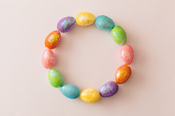Colorful Easter eggs on pastel pink background. Easter decoration with space for text. Top view, flat lay, copy space
