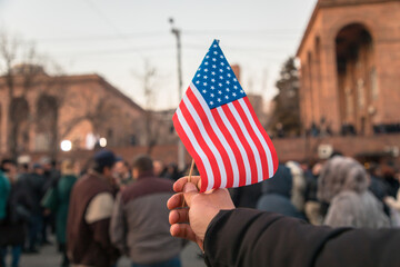 man holding American flag in street