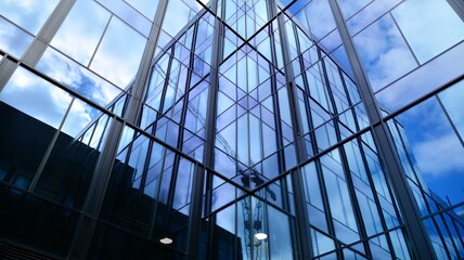 Modern office building with glass facade on a clear sky background. Transparent glass wall of office building.