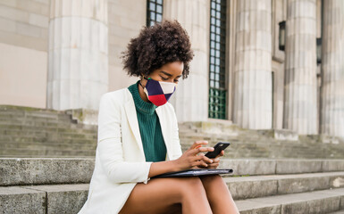 Business woman using her mobile phone outdoors.