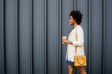 Fototapeta na wymiar Portrait of afro business woman walking outdoors.