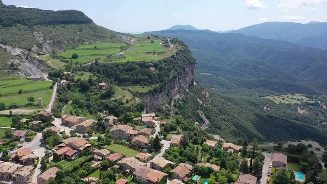 Picturesque green summer landscape with ancient stone buildings of Tavertet town on top of cliff, Collsacabra, Catalonia, Spain. High quality 4k footage