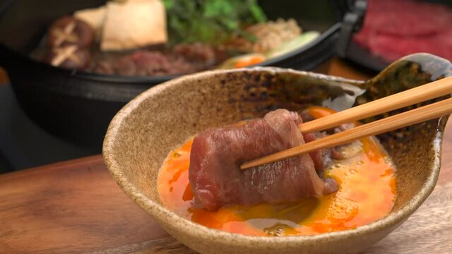 すき焼きの牛肉に生卵をつけて食べる