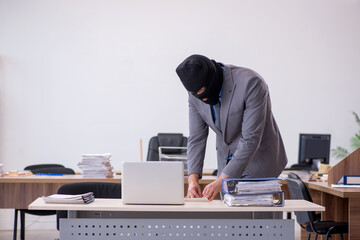 Young male employee in industrial espionage concept