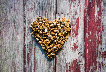 Heart health nuts, snack, in the shape of a heart on a wood table. 