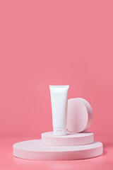 White tube on an light pink podiums. White blank unbranded flacons with cosmetology products....