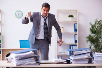 Young employee angry with excessive work holding knife