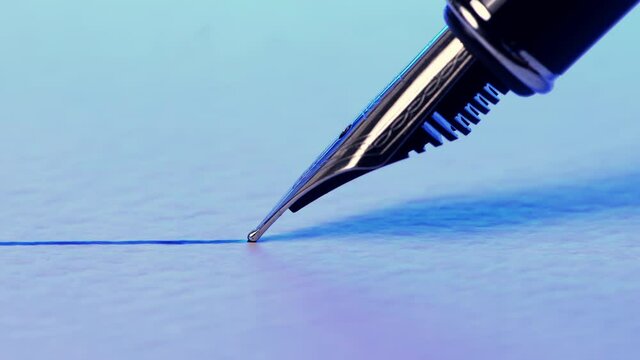 Closeup view of a fountain pen drawing a straight ink line on a textured paper surface