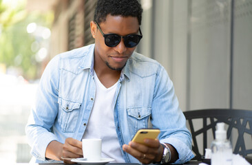 Man using his mobile phone at coffee shop.