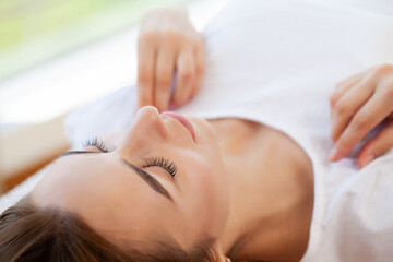 Young pretty woman enjoying face massage procedure