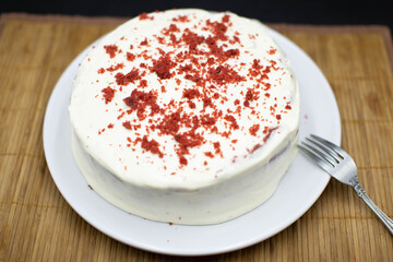 Delicious homemade red velvet cake with candles on table against brick wall. Space for text