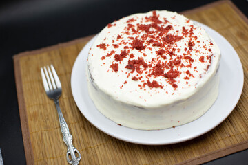 Delicious homemade red velvet cake with candles on table against brick wall. Space for text