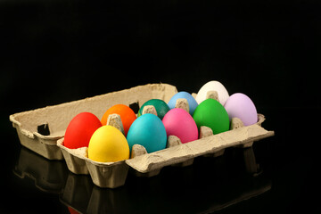Easter festive multicolor eggs carton, black copy-space background