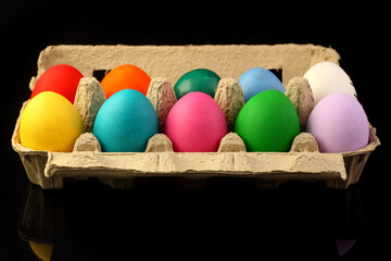 Easter festive multicolor eggs carton, black copy-space background