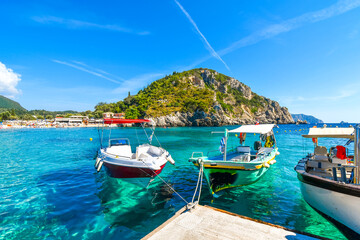 Fototapeta na wymiar Small boats at a dock in the harbor of Palaiokastritsa beach on the Aegean island of Corfu, Greece.