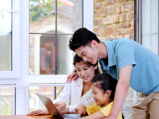 Happy family of three using laptop