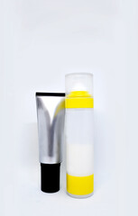 Bottles of gray-black and white-yellow colors with cosmetics. Vertical format. There is a place for text or logo
