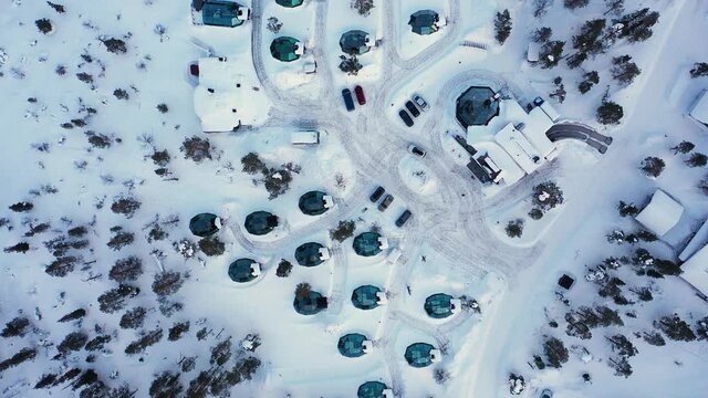 Aerial view above aurora igloos and huts, winter, in Lapland - top down, drone shot