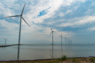 Modern windmills built on a narrow dam on the west coast of Denmark, Nissum Bredning Bay