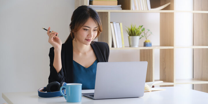 Businesswoman In Having A Video Call On Laptop While Discussion With Business Partner During Work From Home.