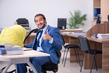 Young male employee looking after new born at workplace