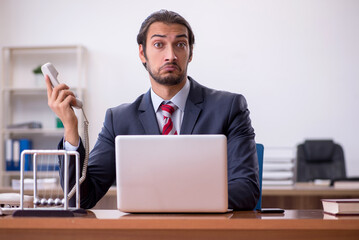 Young man businessman employee sitting in the office