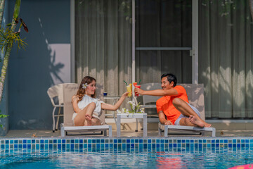 couple having goodtime together on summer vacation in resort and hotel garden beside pool