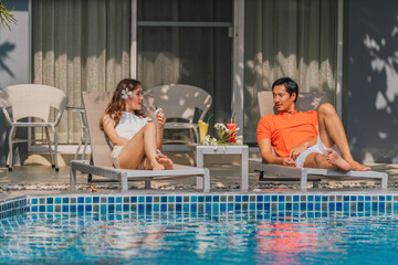 couple having goodtime together on summer vacation in resort and hotel garden beside pool