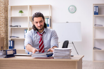 Fototapeta premium Young male employee unhappy with excessive work