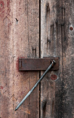 old rusty door handle with large nail