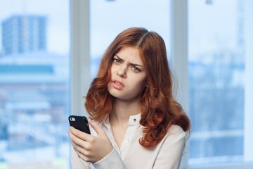 red-haired woman with a phone in her hands communicating an official