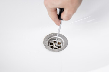 handyman repairing or cleaning clogged sink drain at bath. plumber service concept